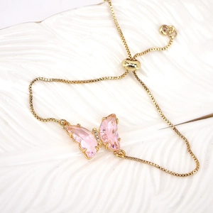 Detail view of pink rhinestone butterfly charm on adjustable gold box chain bracelet