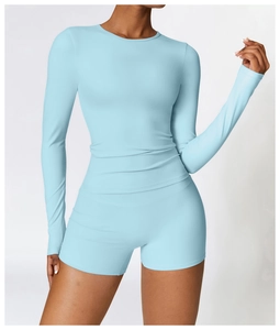 Détail d'ensemble de yoga bleu clair avec haut à manches longues et short de sport ajusté