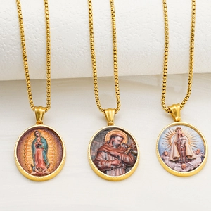 Pendenti religiosi ovali in oro 18 carati su collane di perle in una scena minimalista