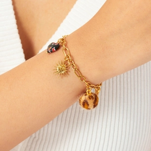 Gold stainless steel bracelet with sun pendant, heart bead and leopard print charm on wrist
