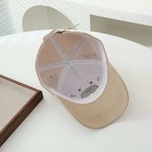 Detailed interior of a beige cotton baseball cap featuring reinforced stitching and embroidery