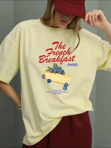Pale yellow 100% cotton T-shirt featuring French breakfast print on a female model