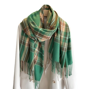 Sciarpa a quadri verdi effetto cashmere con nappe appesa a una gruccia con un blazer