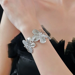 Détail d'un grand bracelet manchette fleur argentée avec texture de pétales radiale