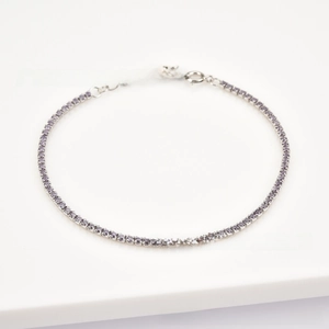 Detailed macro view of S925 silver tennis bracelet with purple zircon and lobster clasp