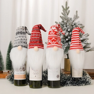 Set of four festive Christmas gnome wine bottle covers with knitted hats and plush beards
