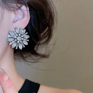 Elegant silver flower stud earrings with sparkling white crystals for a luxury party look