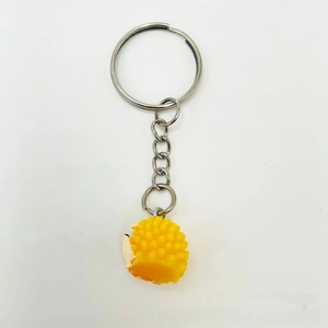 Close-up of yellow cartoon hedgehog resin keychain with soft textured round spikes