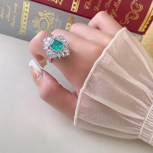 Dettaglio dell'anello di zircone verde smeraldo con incastonatura di diamanti lucidi