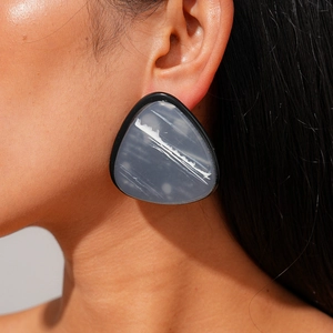 Geometric resin triangle earrings with grey marble pattern and black border on model