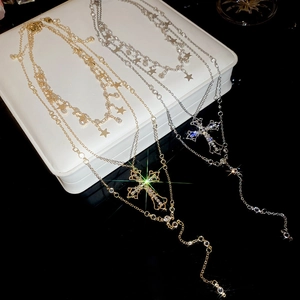 Detail of layered gold and silver cross star necklaces with sparkling rhinestones