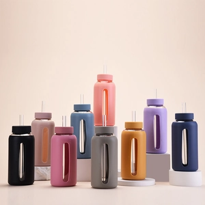 Close-up of assorted colorful silicone sleeves on 800ml glass water bottles with straws