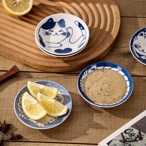 Japanese style ceramic cat sauce dishes with blue and white patterns on wooden table