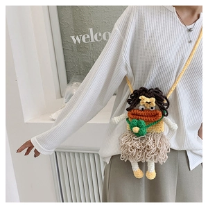 Detail of handmade knit sausage mouth shoulder bag with cute doll features and tassels