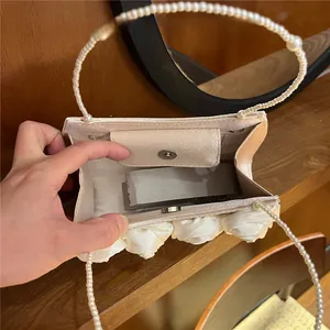 Detailed interior of vintage cream satin handbag with faux pearl handle and magnetic closure