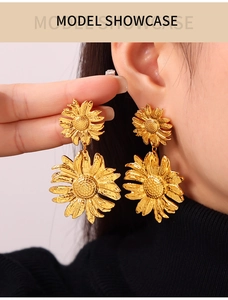 Model wearing golden sunflower drop earrings with detailed petal texture and floral design
