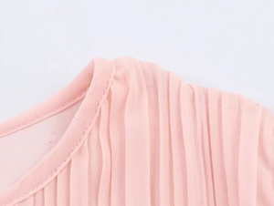 Close-up of pink pleated chiffon dress detailing with high-quality texture and ruffles