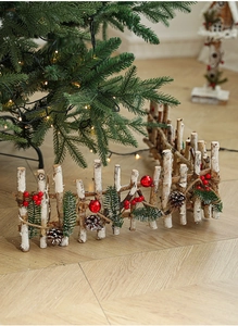 Close-up of wooden Christmas fence with artificial pine needles and red berries decor