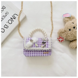 Detail of tweed girl's mini bag with pearl handle, diamond crown and number 5
