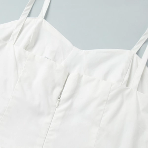 Détail de robe blanche en coton avec fines bretelles et fermeture éclair invisible