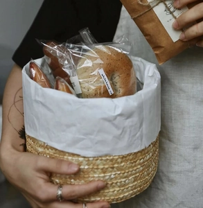 Close-up of round straw storage basket with white lining and hand-woven natural texture