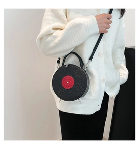 Detail of creative vinyl record shaped bag with red center and metallic studs