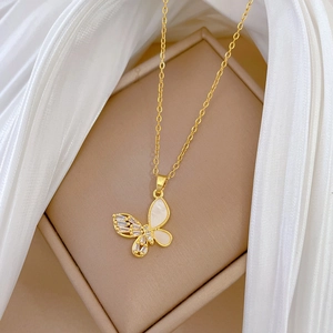 Elegant gold butterfly necklace with shell inlay and crystals on silk background