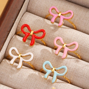 Set of five colorful enamel bow rings in gold plating organized in a jewelry box