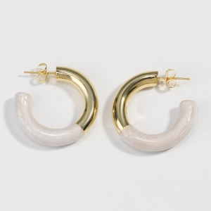 Vue détaillée des boucles d'oreilles C dorées avec incrustation de résine marbrée