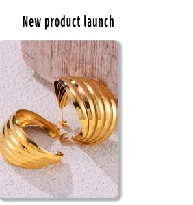 Macro detail of gold layered textured earrings with metallic finish on stone surface
