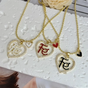 Dettaglio dei ciondoli a cuore placcati in oro 18K con lettere Fe e zirconi