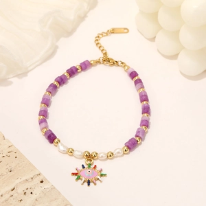Bracciale occhio greco con perline viola e pendente sole su elegante sfondo crema