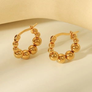 Detailed view of gold-plated beaded ball hoop earrings with high-gloss metal finish