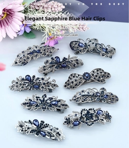 Vue à plat de neuf barrettes vintage argentées avec strass bleu foncé et motifs floraux