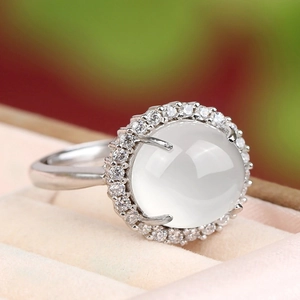 Macro shot of silver ring with translucent white gemstone and halo micro-diamonds