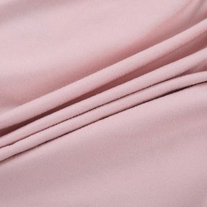 Close-up of soft light pink knit fabric with detailed texture and ribbed pattern