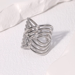 Dettaglio macro dell'anello geometrico cavo d'argento su sfondo bianco materico