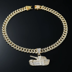 Detailed close-up of a gold Cuban chain and tank pendant encrusted with sparkling crystals