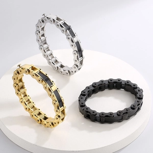 Detailed view of three motorcycle chain bracelets in gold, silver, and black with carbon fiber