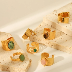 Detailed close-up of vintage gold stainless steel rings with natural stones on stone