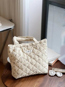 Gros plan du sac en velours côtelé matelassé beige avec motifs floraux et rembourrage