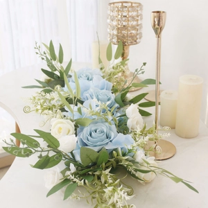 Close-up of blue and white silk rose flower row arrangement on elegant table setting