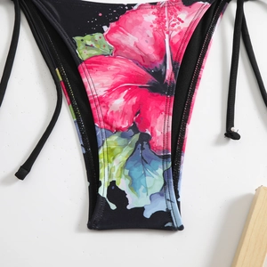 Detail of floral bikini bottom with pink hibiscus print and side tie strings on white