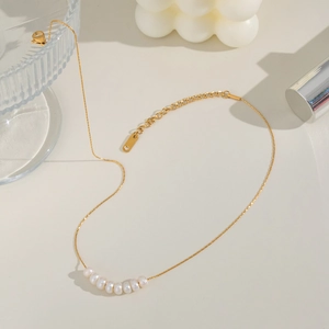 Detailed view of small natural pearls on a gold plated waterproof necklace chain