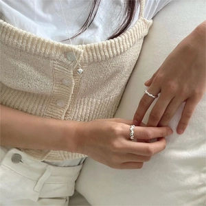 Minimalist 925 sterling silver knotted rings and necklace worn by model in a chic style