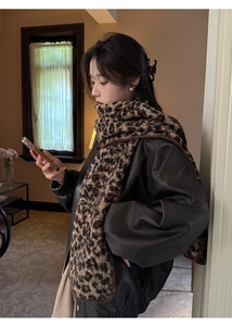 Close-up of stylish leopard print scarf with soft faux wool texture on leather jacket