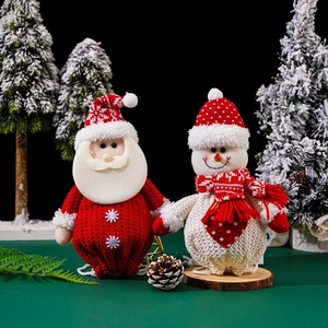 Detail of knitted Santa Claus and snowman plush figures with festive mini pine cones