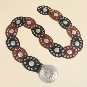 Detail of bohemian waist belt featuring mixed brown and black oval patches and silver buckle
