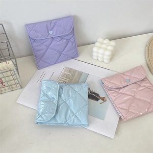 Close-up of quilted sanitary pouch with heart button closure in pastel colors