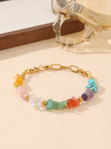 Macro shot of colorful irregular gravel stones on a gold stainless steel chain bracelet
